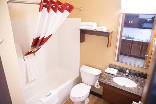 a bathroom with a toilet and a tub and a sink at White House Suites in Plainfield