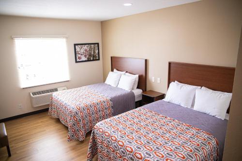 a hotel room with two beds and a window at White House Suites in Plainfield