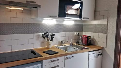 une cuisine avec un évier et un plan de travail dans l'établissement Balcony of lake Geneva, à Thollon-les-Mémises