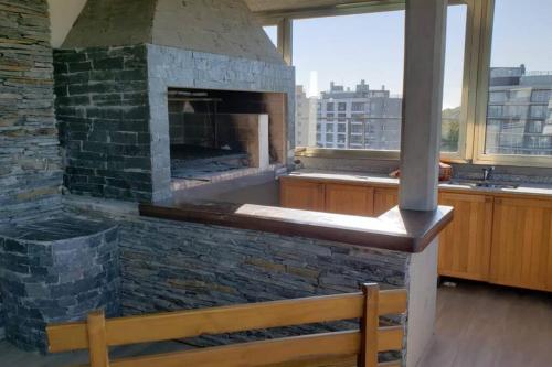 una gran chimenea de piedra en una habitación con banco en Semipiso de categoria en Pinamar