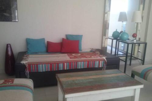 uma sala de estar com uma cama com almofadas vermelhas e azuis em Semipiso de categoria em Pinamar