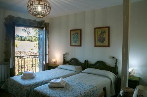 a bedroom with a bed and a large window at Posada El Tesin in Rabanal del Camino