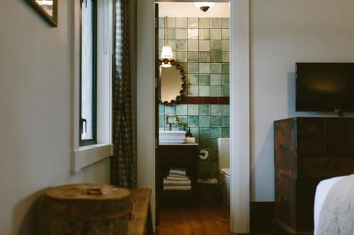 a bathroom with a sink and a toilet and a mirror at The Convent Hotel in Auckland