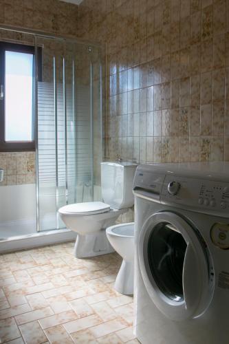 a bathroom with a toilet and a washing machine at Casona de Rabanal-Oca in Rabanal del Camino