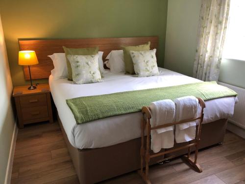 a bedroom with a large white bed with a green blanket at Corner Cottage - character, charm, great location. in Ringwood