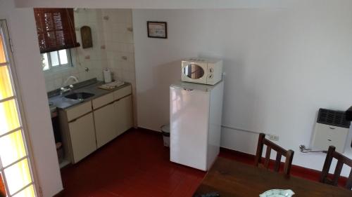 a small kitchen with a microwave on top of a refrigerator at La Daimalé Apart in Colón