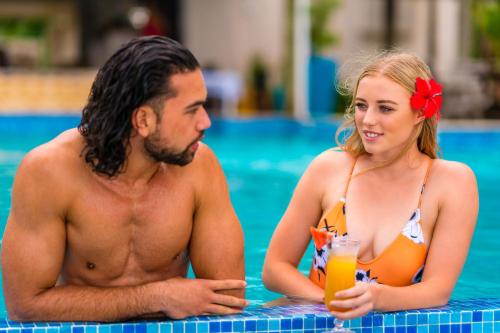 a man and a woman sitting in a swimming pool at Little Polynesian Resort in Rarotonga