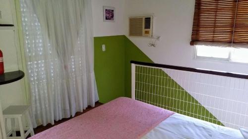 a green and white bedroom with a bed and a window at La Daimalé Apart in Colón