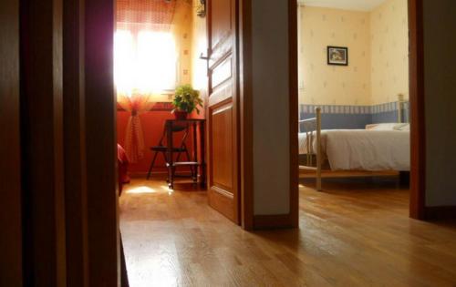 eine offene Tür zu einem Schlafzimmer mit einem Bett und einem Tisch in der Unterkunft Chez Mamie Riclaude in Orsan