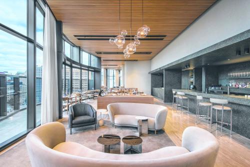 a restaurant with couches and chairs and a bar at Eos by SkyCity in Adelaide