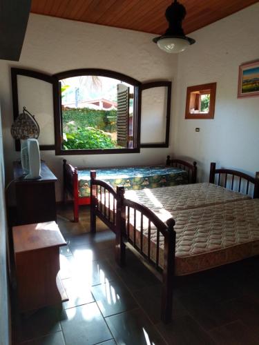 Un dormitorio con una cama grande y una ventana en Casa com piscina em condomínio fechado no Guarujá en São Paulo