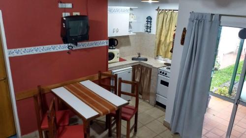 a small kitchen with a table and a tv on the wall at La Daimalé Apart in Colón