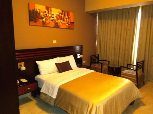 a hotel room with a bed and a chair at Gran Hotel Ica in Ica