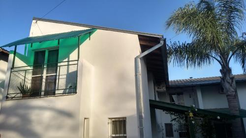 a white building with a palm tree in front of it at La Daimalé Apart in Colón
