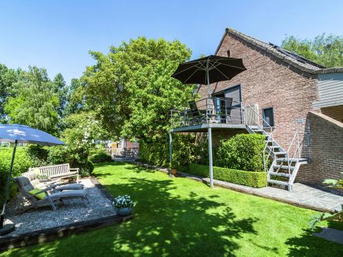 a yard with a patio and an umbrella at Cushy Apartment with Private Terrace Heating in Maldegem
