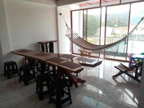 a hammock hanging in a room with a table and chairs at Lindo apartamento vacacional en guaduas in Guaduas