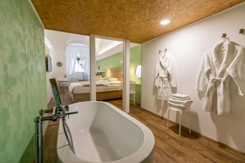 a bathroom with a bath tub and a bedroom at Palác Daun - Studio Apartments in Znojmo
