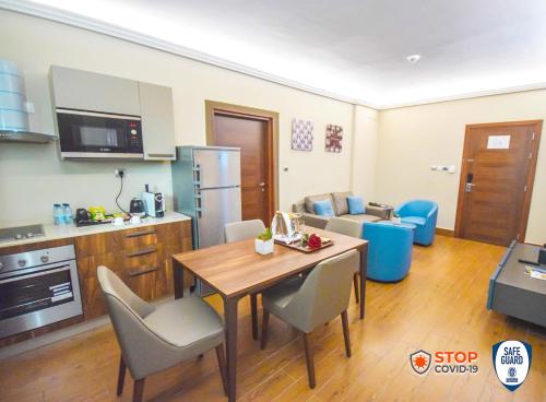 a kitchen and living room with a table and chairs at Hotel La Falaise Bonapriso in Douala