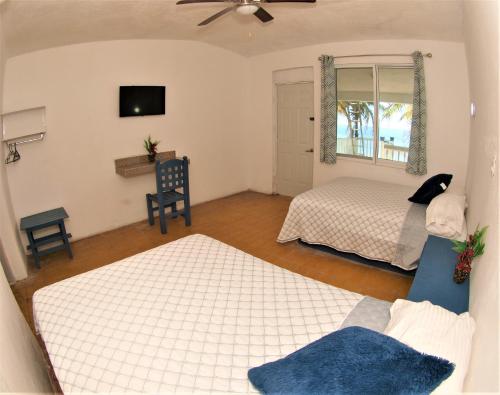 1 dormitorio con 2 camas, ventana y sofá en Hotel El Paraíso, en Armería