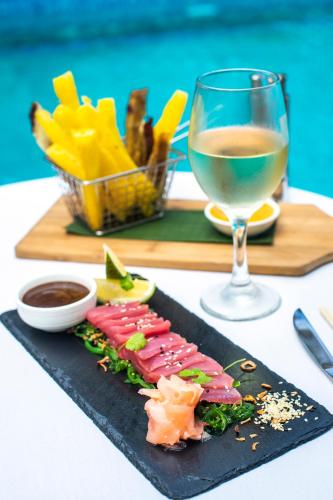 a plate of sushi and a glass of wine at Little Polynesian Resort in Rarotonga