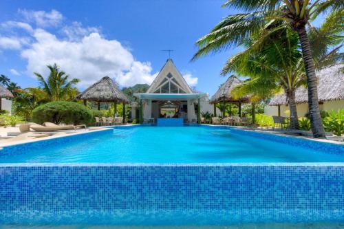 a swimming pool in front of a villa at Little Polynesian Resort in Rarotonga