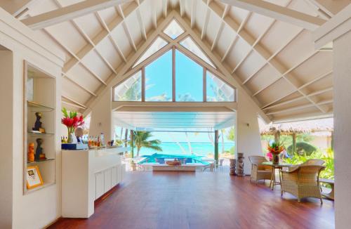 an open living room with a vaulted ceiling and a large window at Little Polynesian Resort in Rarotonga