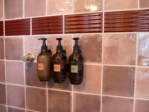 a group of four bottles on a tiled wall at The Convent Hotel in Auckland
