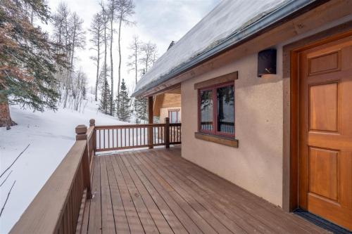 a house with a wooden deck in the snow at Double Eagle Way 102 in Telluride