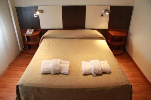 een slaapkamer met een bed met twee handdoeken erop bij Kalton in San Rafael