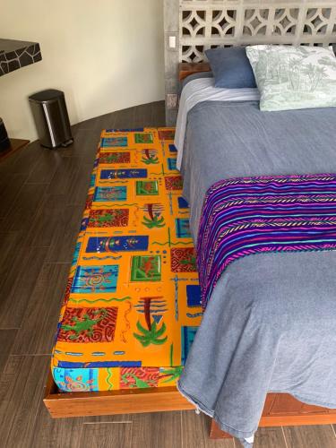 a colorful rug on the floor next to a bed at Playa Bruja Zicatela in Puerto Escondido