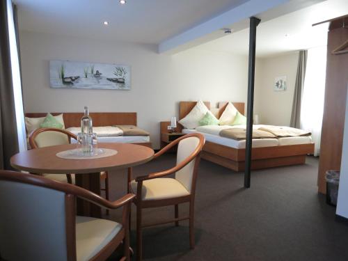 a hotel room with a bed and a table and a bed at Gästehaus "Auszeit" in Burgschwalbach