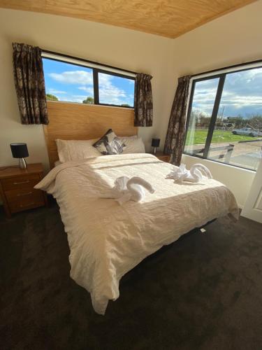 sypialnia z dużym łóżkiem i dużym oknem w obiekcie Country Retreats on Ranzau 2 w mieście Nelson