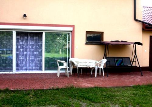 a patio with a table and chairs next to a building at Apartamenty Górki Małe in Tuszyn