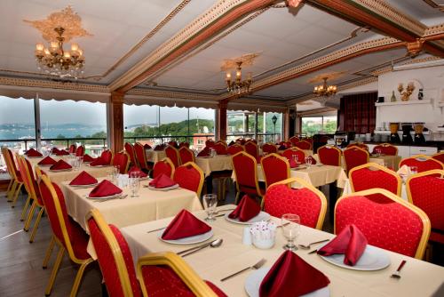 uma sala de jantar com mesas e cadeiras com assentos vermelhos em Golden Horn Hotel em Istambul