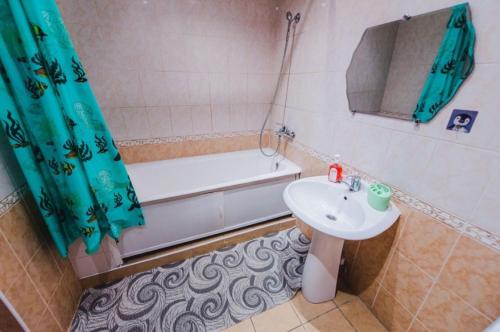 a bathroom with a sink and a bath tub at Dekabrist Apartment at anokhina 93 in Chita