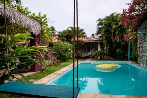 a swimming pool in front of a house at Bada Hostel & Kite School in Cumbuco