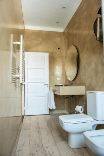 a bathroom with a toilet and a sink and a mirror at Casa Lola in Yerba Buena