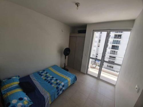 a bedroom with a bed and a large window at Apartamento Girardot in Girardot
