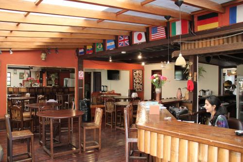 a woman sitting at a bar in a restaurant at Hostal Alcala in Quito