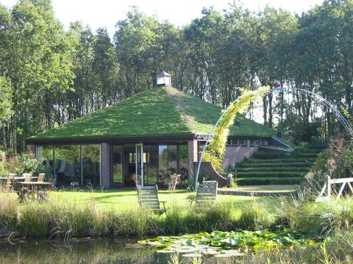 a gazebo with a green roof and a roller coaster at Selatuinen in Appelscha