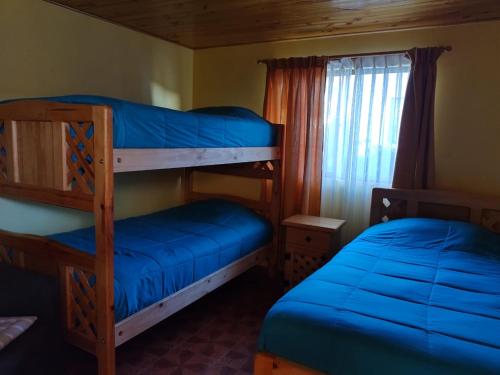 1 dormitorio con 2 literas y ventana en Cabañas Cadizmar, en Pichidangui