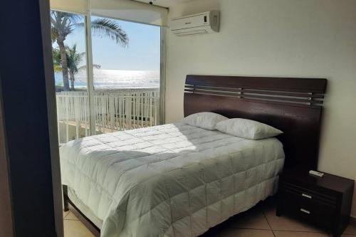 a bedroom with a bed and a view of the ocean at Departamento 105 , paraiso del pacifico in Coyuca