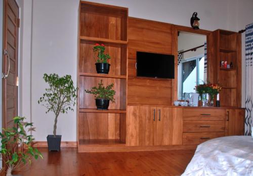 a bedroom with a wooden entertainment center with a television at Cottage San Francesco in Nuwara Eliya