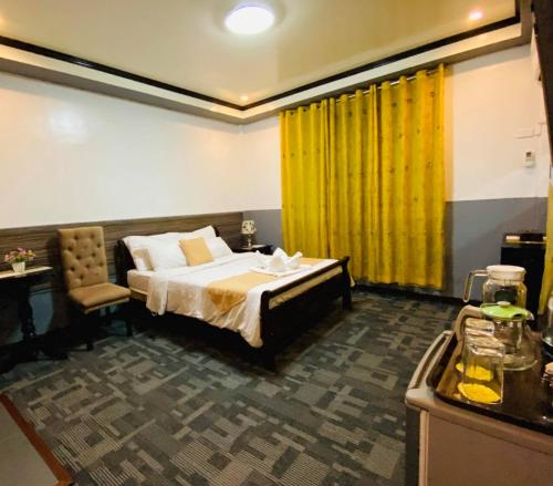 - une chambre avec un lit et un rideau jaune dans l'établissement Amax Inn Makati, à Manille