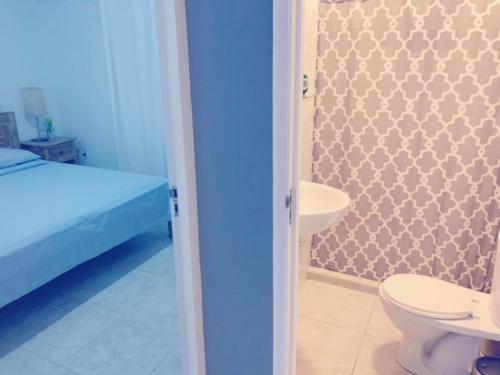 a bathroom with a bed and a toilet and a sink at Apartment Curacao in Willemstad