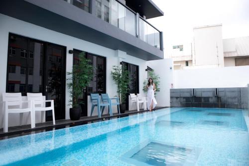 a woman standing next to a swimming pool on a building at Hotel NuVe Urbane in Singapore