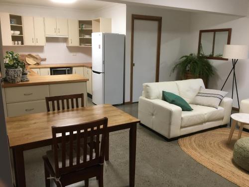 a kitchen and living room with a table and a couch at Lower Mountains Retreat in Warrimoo