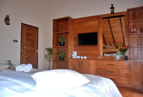 a bedroom with a bed and a large wooden cabinet at Cottage San Francesco in Nuwara Eliya