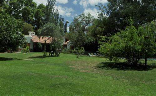 a yard with a house and trees and grass at La casita en el parque in Chacras de Coria