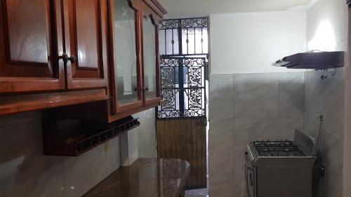 uma pequena cozinha com um fogão e uma janela em Casa amueblada - Mazatlán em Mazatlán